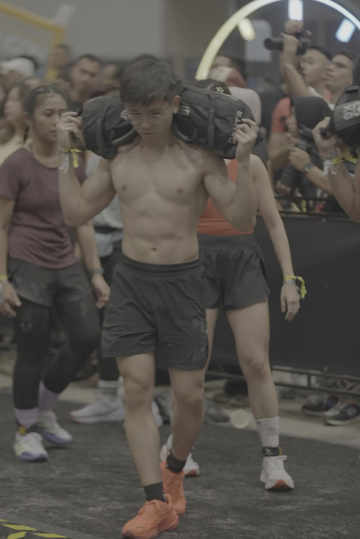 Jeremiah Lung carrying a sandbag during a HYROX race
